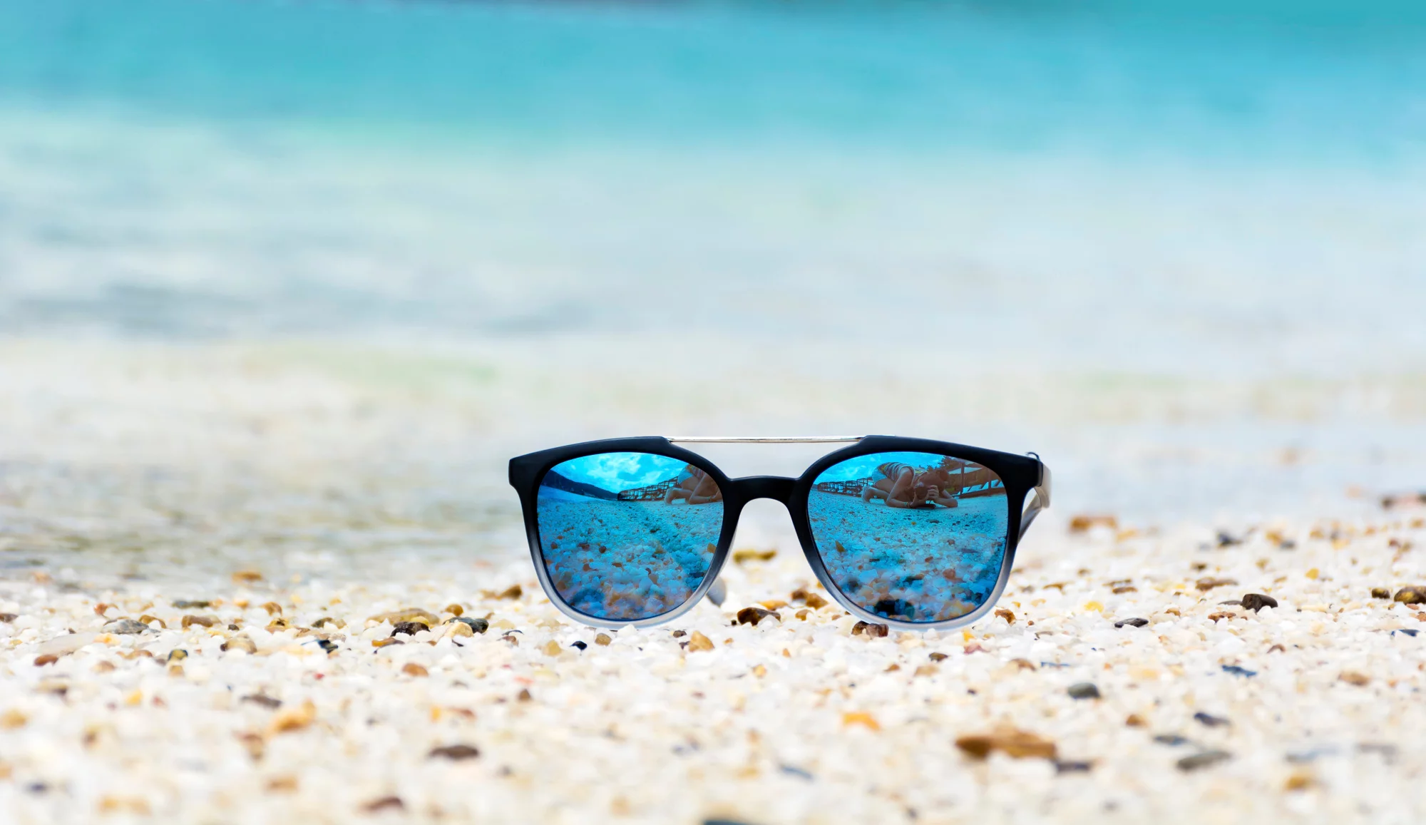 Les lunettes de soleil chez Optique Lamorère à Biscarrosse Lunettes de soleil posées sur le sable, verres chromés