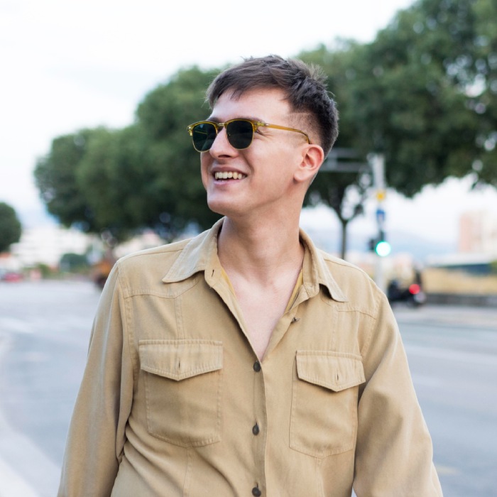 Homme souriant avec des lunettes de soleil tendance